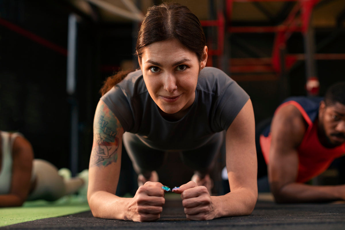 Person doing a plank exercise in a gym setting.